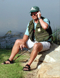 Photo of Jeff Kessel taking a business phone call while out fishing